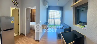 Modern living room with sleek design, featuring a cozy sofa, air conditioning, and a view of the bedroom.