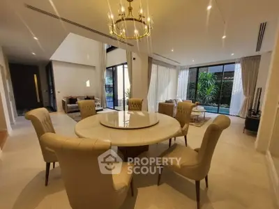 Luxurious open-plan living room with elegant dining area and pool view, perfect for entertaining.