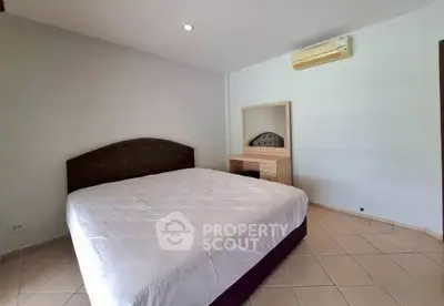 Spacious bedroom with modern furnishings and air conditioning in a stylish real estate property.