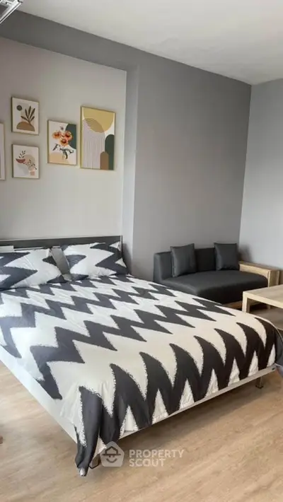Modern bedroom with stylish decor and cozy seating area, perfect for relaxation.