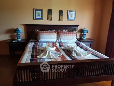 Cozy bedroom with elegant wooden bed and artistic decor, perfect for relaxation.