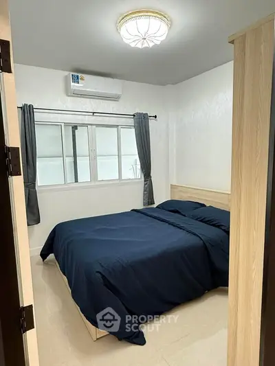 Cozy bedroom with modern decor and natural light, featuring a comfortable bed and stylish curtains.