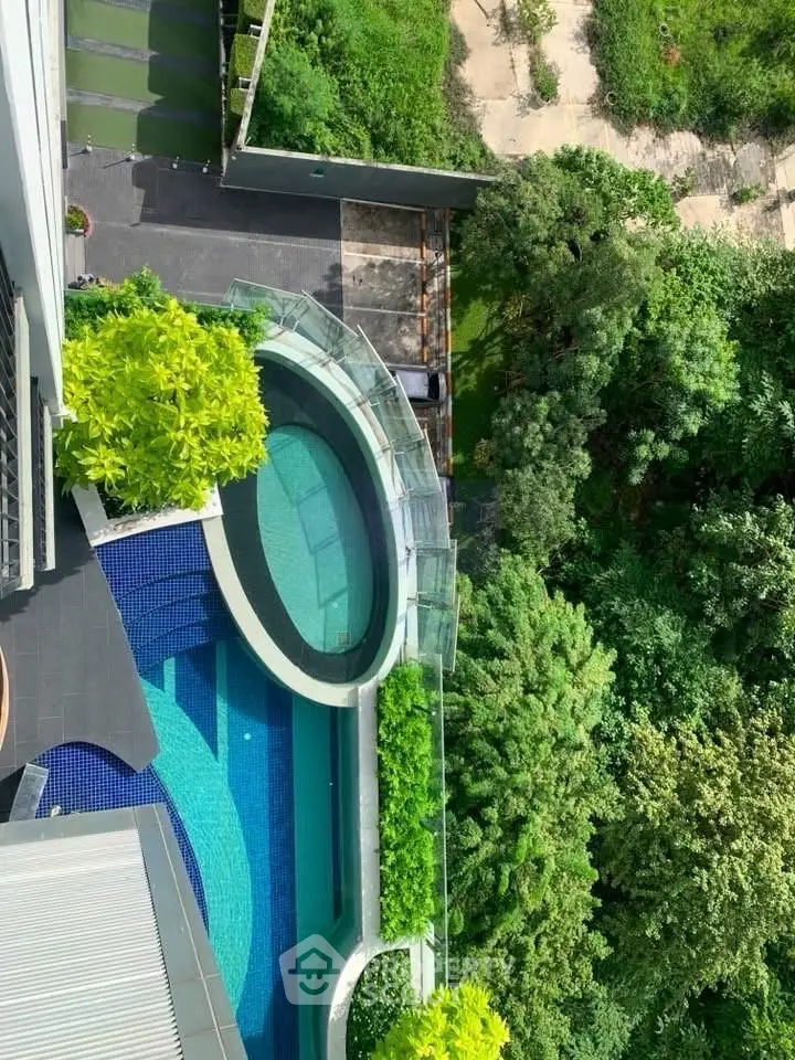 Stunning aerial view of luxurious pool and lush greenery in modern residential complex.