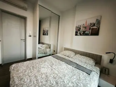 Cozy bedroom with modern decor and mirrored wardrobe in stylish apartment.