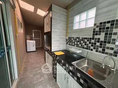 Modern kitchen with sleek black countertops and stylish tile backsplash