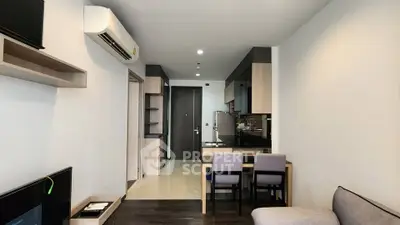 Modern open-plan living room with sleek kitchen and dining area, featuring contemporary furniture and stylish decor.