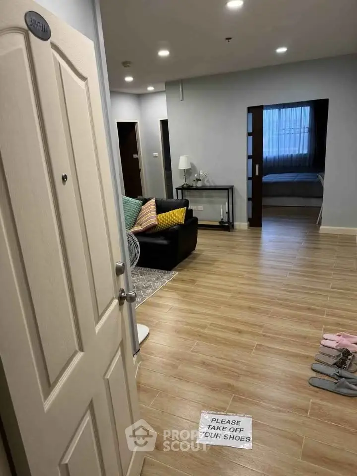 Spacious apartment entrance with cozy living area and inviting bedroom view.