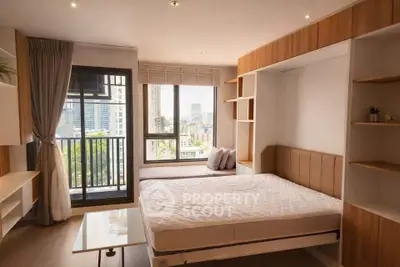 Modern bedroom with large windows and city view, featuring built-in storage and stylish decor.