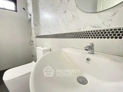 Modern bathroom with stylish sink and marble wall tiles