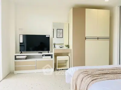 Modern bedroom with sleek furniture and cozy decor, featuring a TV and ample storage space.