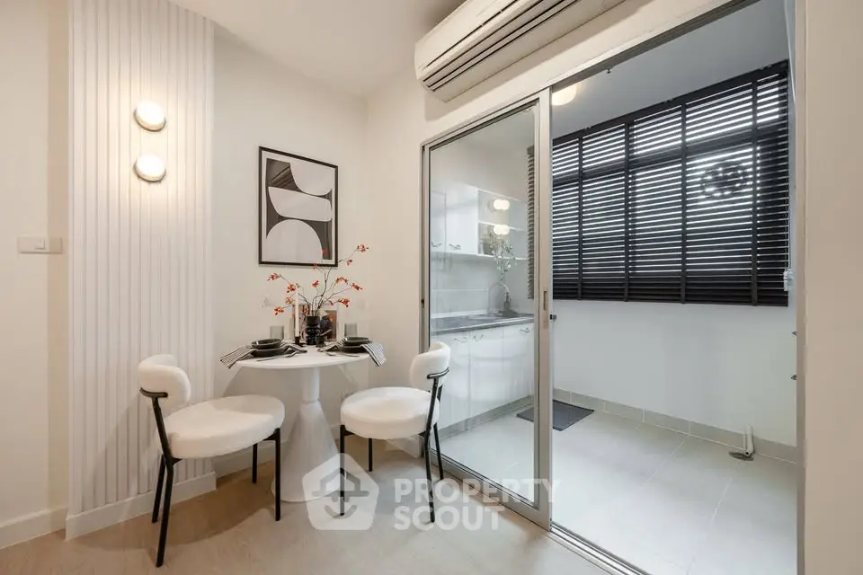 Modern dining area with stylish decor and sliding glass door to kitchen
