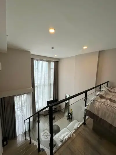 Modern loft apartment with high ceilings and large windows, featuring a cozy living area and stylish bedroom.