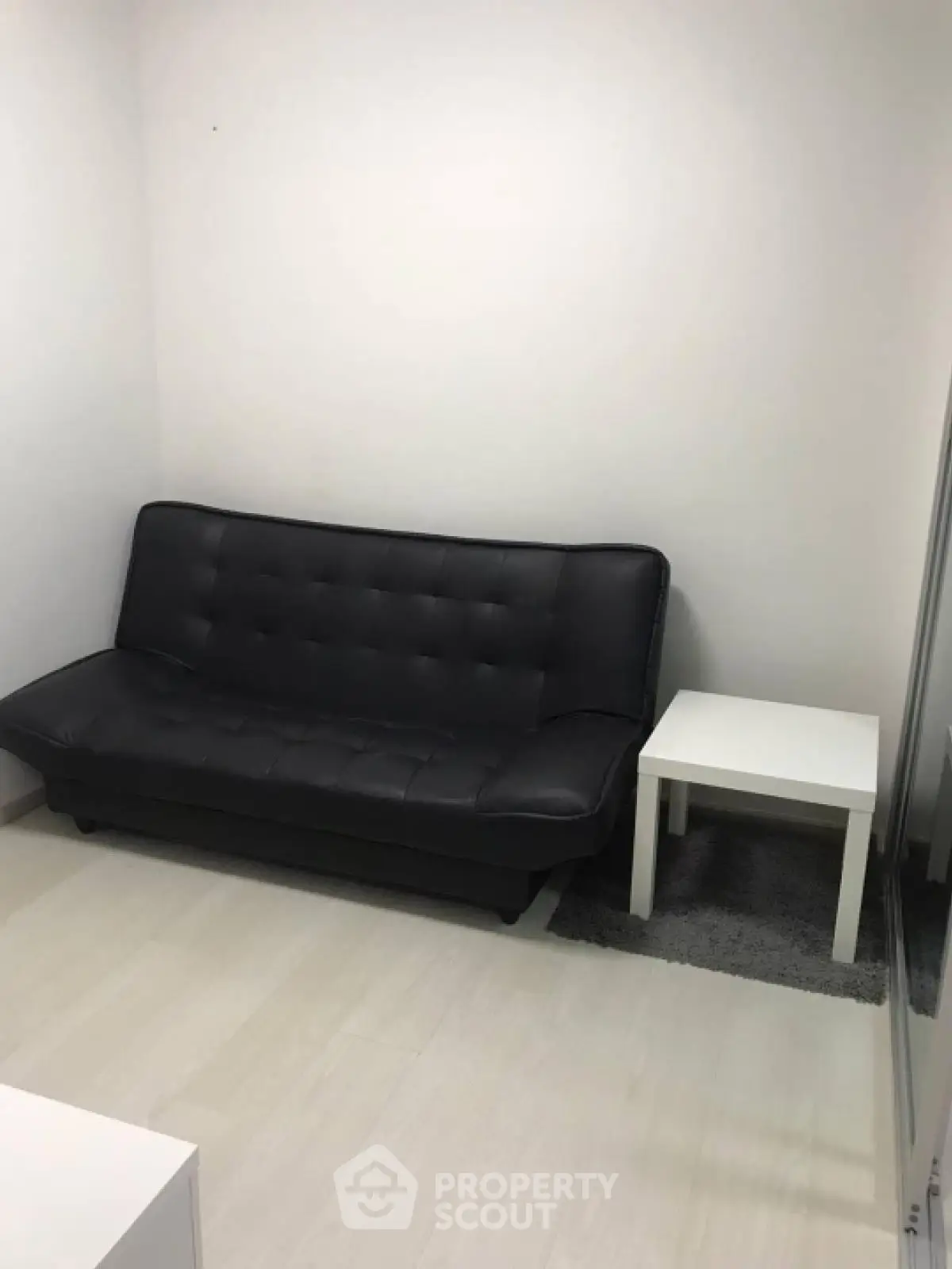 Cozy minimalist living room with black sofa and white side table