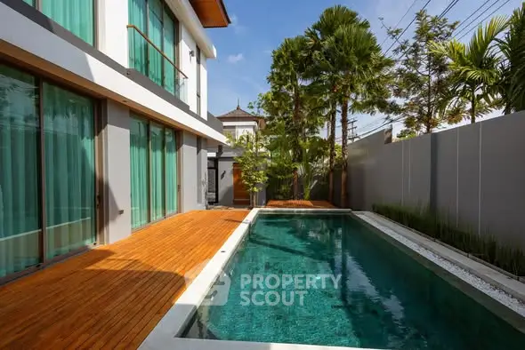 Luxurious modern home with private pool and wooden deck in tropical setting.