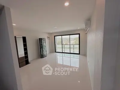 Spacious modern living room with large windows and balcony view