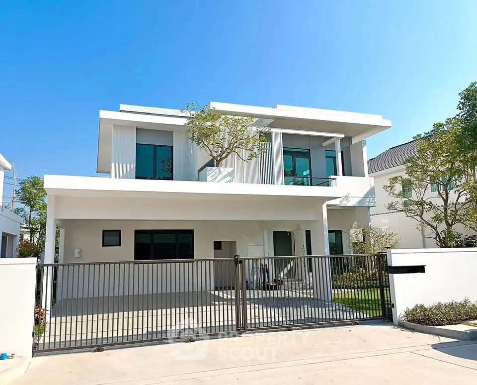 Modern two-story white house with sleek design and gated entrance