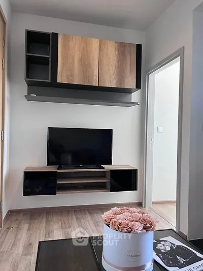 Modern living room with sleek TV unit and stylish decor in a cozy apartment.