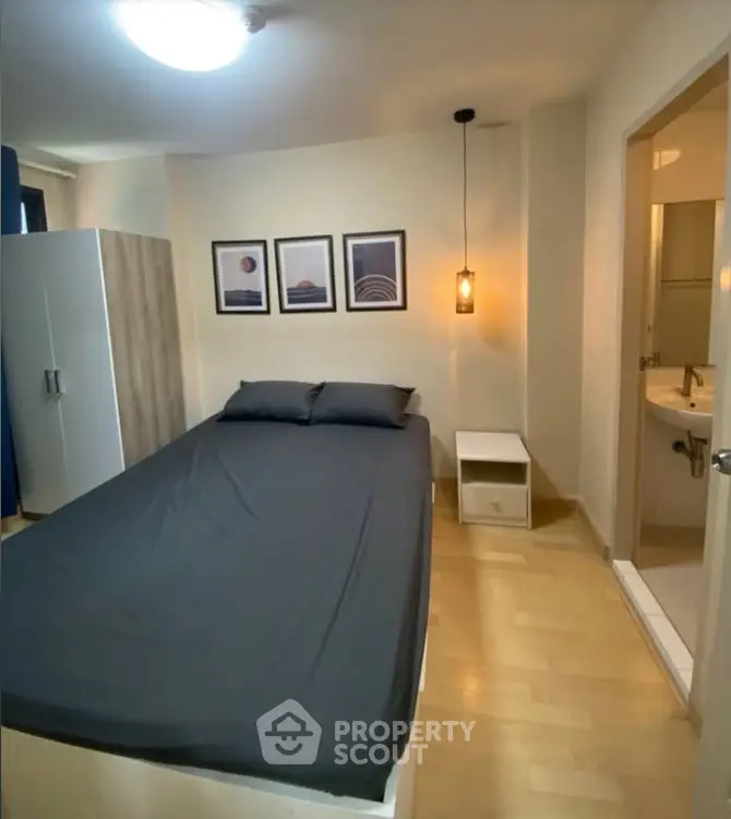 Cozy bedroom with modern decor and ensuite bathroom in stylish apartment.