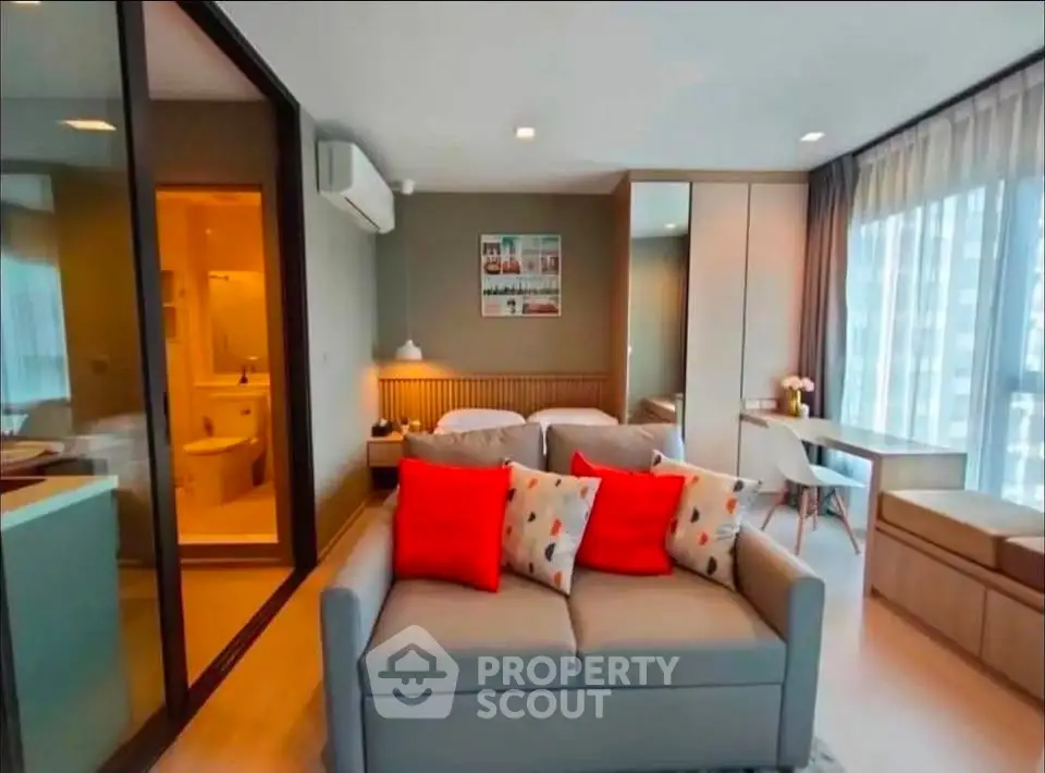 Modern studio apartment with stylish decor and large windows offering ample natural light.