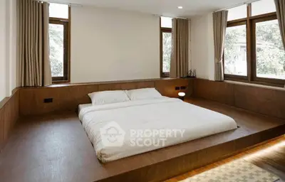 Spacious minimalist bedroom with large windows and wooden platform bed.