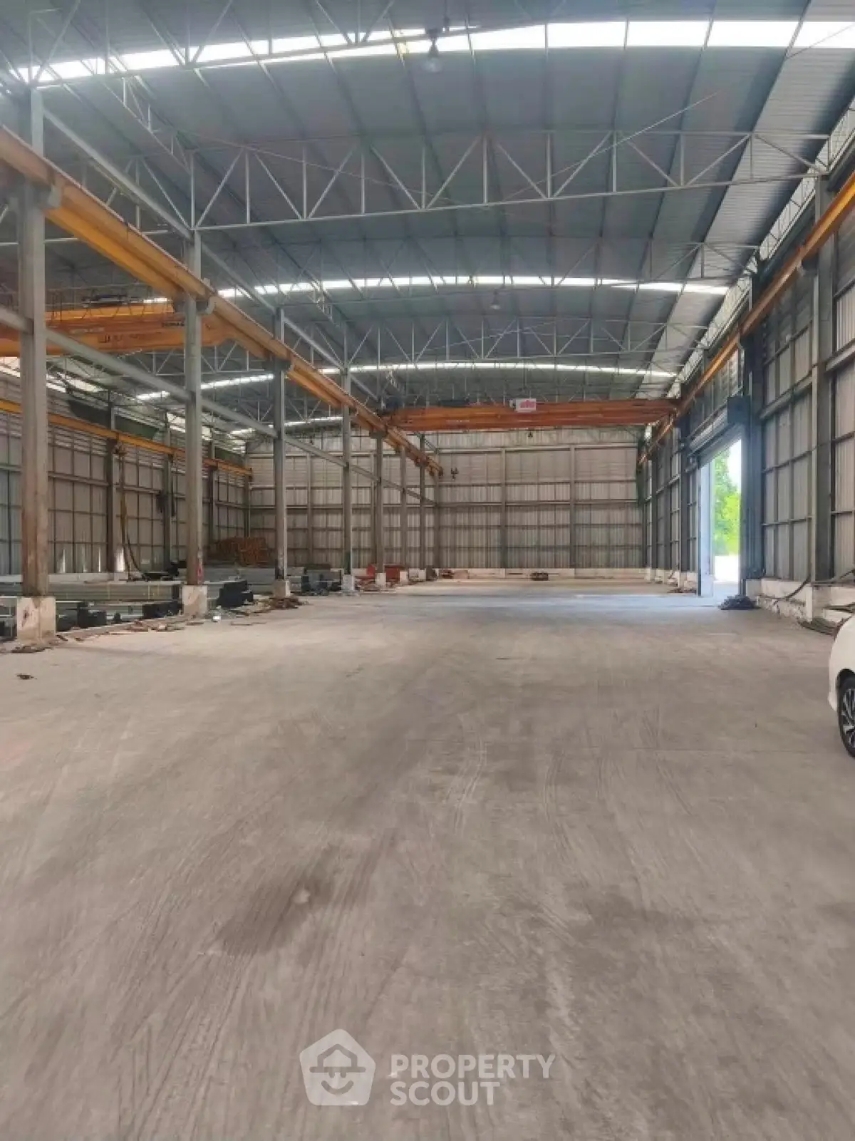 Spacious industrial warehouse with high ceilings and ample natural light, ideal for storage or manufacturing.