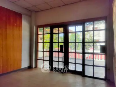 Spacious room with large glass doors leading to a balcony, offering ample natural light and outdoor access.