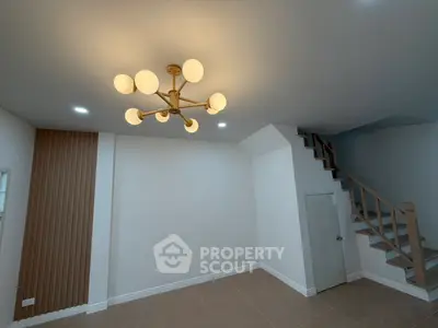 Modern living room with stylish chandelier and staircase