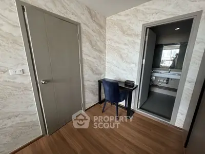 Modern study nook with elegant chair and desk adjacent to a bathroom in a stylish apartment.