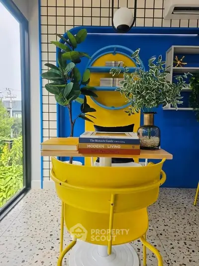 Vibrant modern interior with yellow chairs, blue accents, and lush greenery, perfect for stylish living.