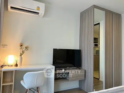 Modern bedroom with desk, TV, and mirrored wardrobe in stylish apartment.