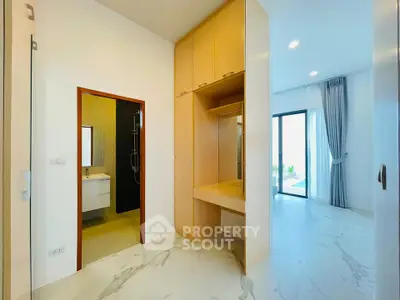 Spacious modern bedroom with ensuite bathroom and built-in wardrobe, featuring elegant marble flooring.