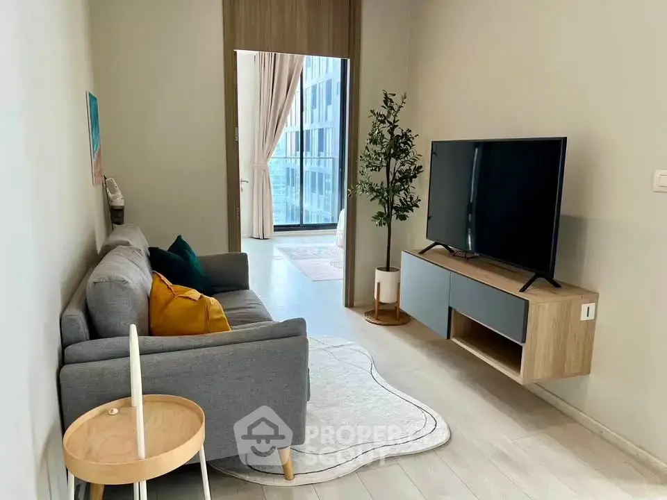 Modern living room with sleek furniture and large TV, featuring a cozy ambiance and stylish decor.