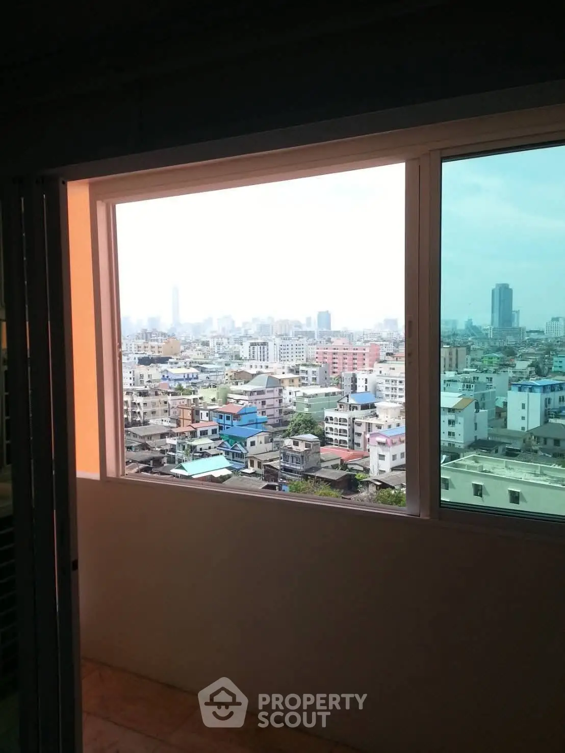 Stunning cityscape view from a high-rise apartment window, showcasing urban skyline.