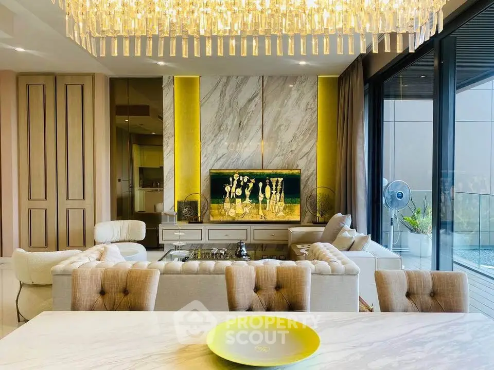 Luxurious living room with elegant chandelier and modern decor, featuring a spacious balcony view.