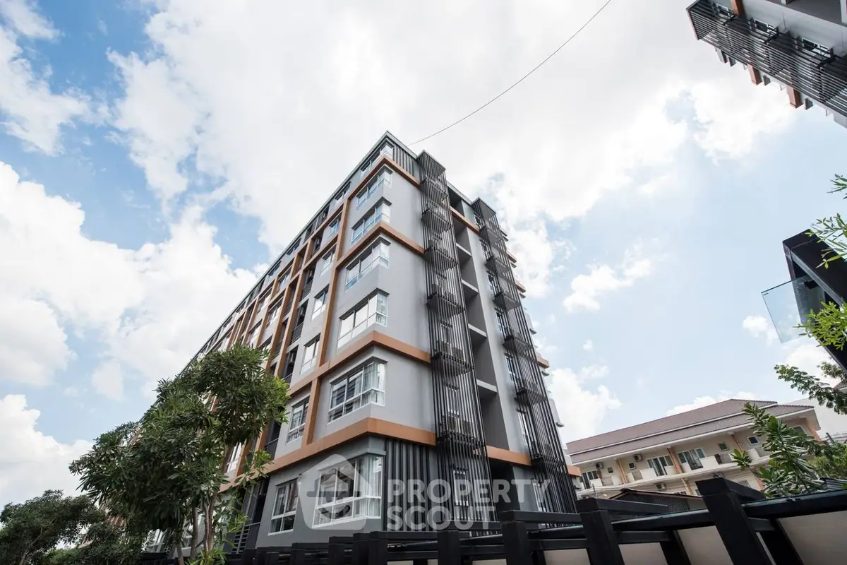 Modern multi-story residential building with a striking facade, showcasing a blend of contemporary design and urban architecture against a clear sky.