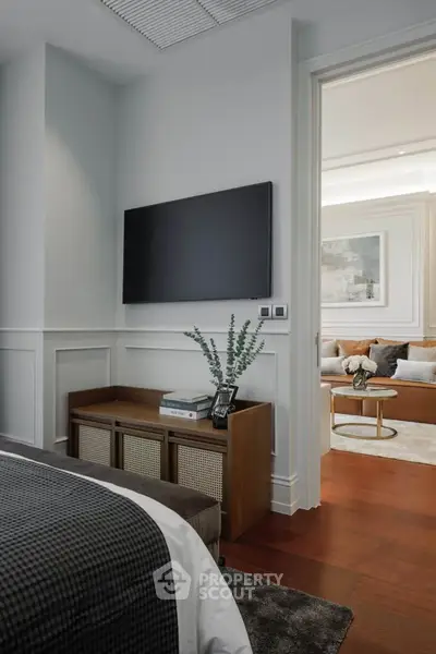 Elegant bedroom with modern decor and view into stylish living room