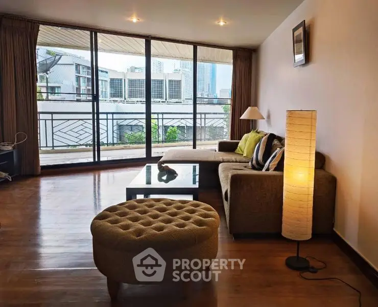 Spacious living room with modern furniture and large windows offering city views.