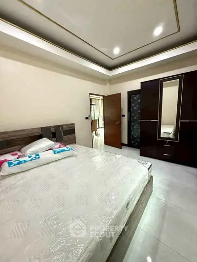 Spacious modern bedroom with elegant ceiling design and sleek wardrobe
