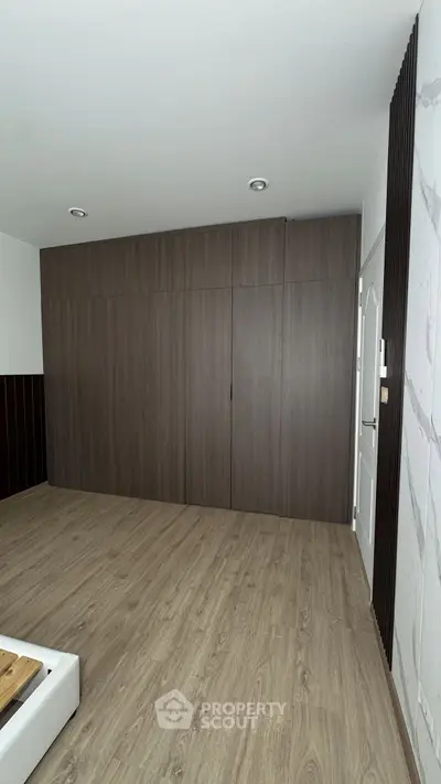 Spacious bedroom with modern wood paneling and sleek flooring