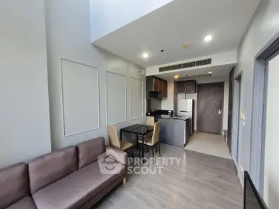 Modern open-plan living room and kitchen with sleek design and natural light