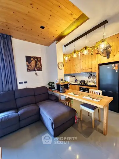 Charming open-layout living room and kitchen with wooden accents and cozy decor.