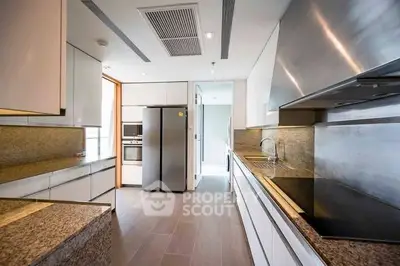 Modern kitchen with sleek design, granite countertops, and stainless steel appliances in a luxury home.