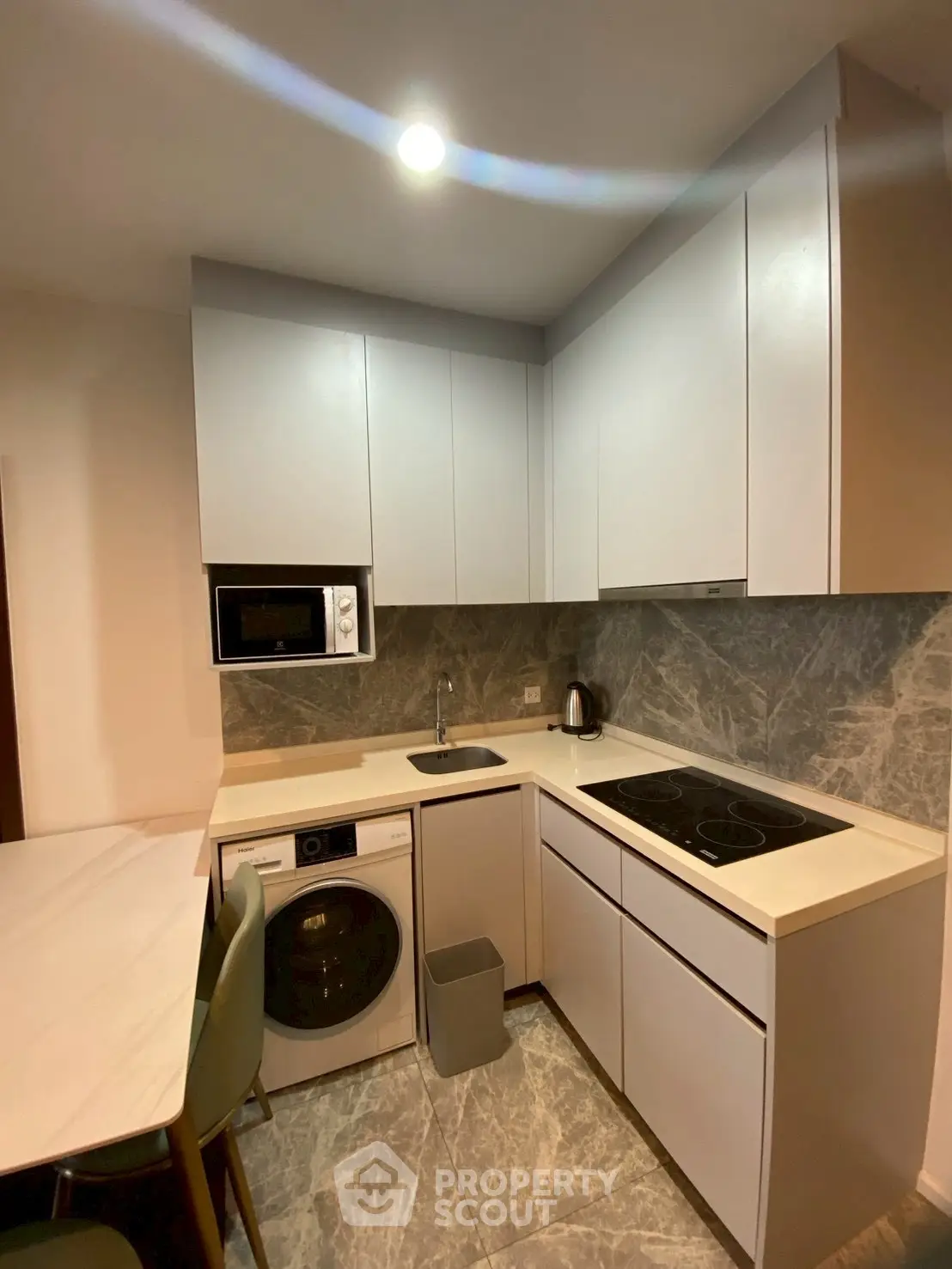 Modern kitchen with sleek cabinetry, built-in appliances, and stylish marble backsplash.