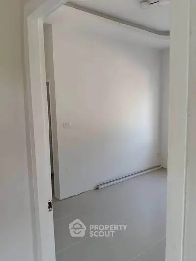 Minimalist interior room with white walls and tiled floor, ideal for customization.