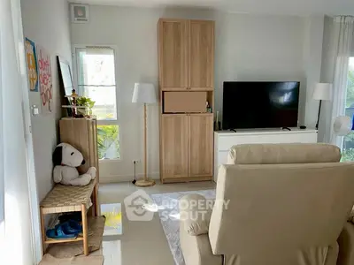 Cozy living room with modern furniture and large TV, perfect for relaxation.