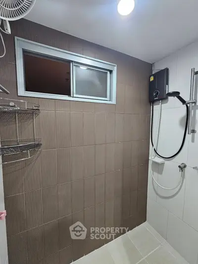 Modern bathroom with shower and window, featuring sleek tiles and a water heater.