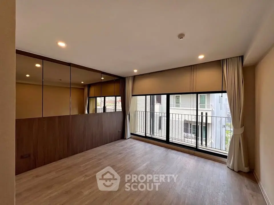 Spacious modern living room with large windows and elegant curtains