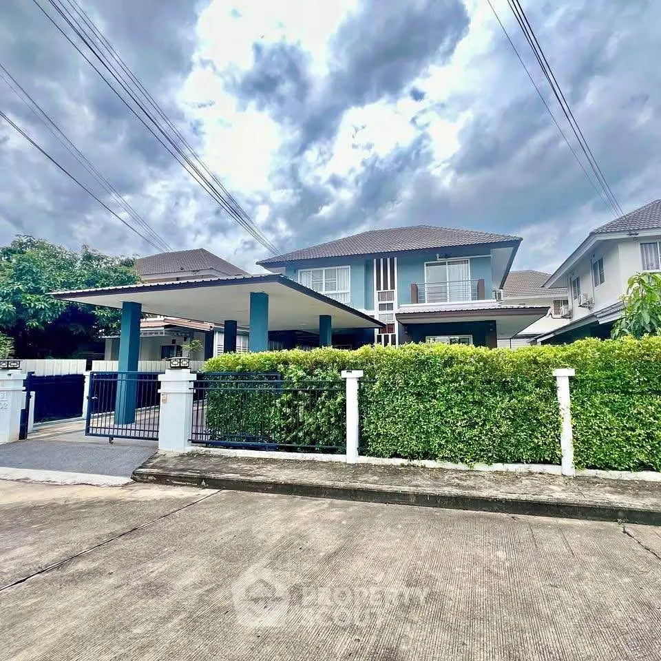Stunning two-story house with lush greenery and spacious driveway in a serene neighborhood.