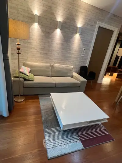 Modern living room with stylish sofa, elegant lighting, and chic coffee table on wooden flooring.