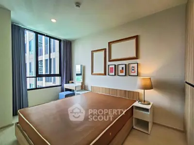 Modern bedroom with large window and stylish decor in a contemporary apartment.